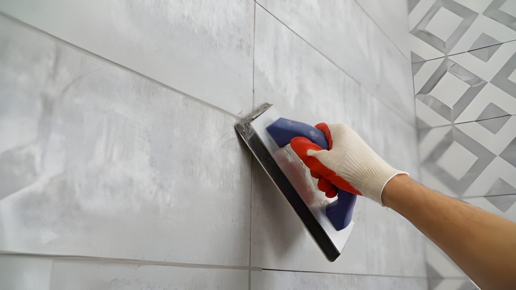 Island Tile Melbourne FL technician applying grout between ceramic tiles during a precision wall installation.